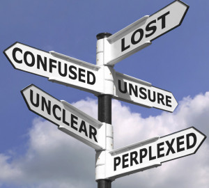 ... image of a lost and confused signpost against a blue cloudy sky