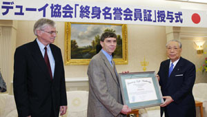 ... Jim Garrison de la Sociedad John Dewey entregan diploma a Daisaku