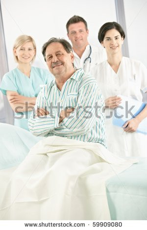patient in hospital smiling at camera with medical team in background ...