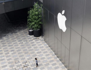 child looks at the Apple logo outside the company's flagship store ...
