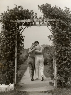 Romantic Couple Walking Through Rose Arbor Photographic Print