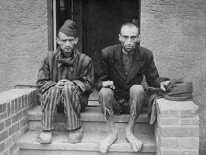 Two emaciated survivors sit outside a barracks in Nordhausen ...