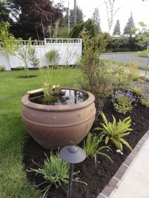 Water garden pot invites guest up the long walk way to the fornt door.