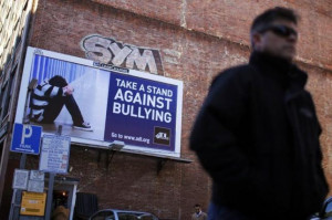 pedestrian walks past an anti-bullying billboard in downtown Boston ...