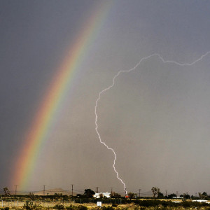 Lightning strikes while a rainbow is formed in the skies over Palmdale ...