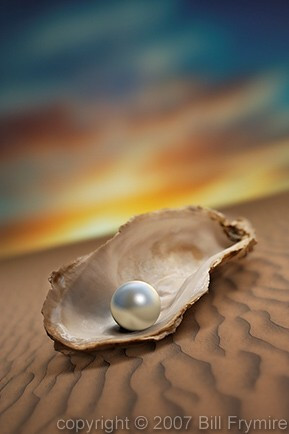 Pearl in an oyster shell on top of sand with sunset-sunrise in ...