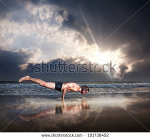 ... man on the beach near the ocean at dramatic sunset sky - stock photo