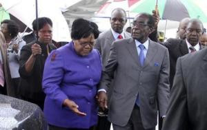 Zimbabwean President Robert Mugabe is greeted by Vice President Joice ...