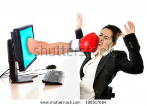 business woman sitting on desk with with computer hit by boxing glove ...