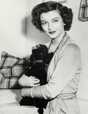 Myrna Loy hugging her poodle 