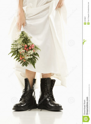 Caucasian bride holding bouquet down by her black combat boots.