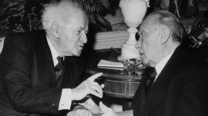 for emphasis, converses with West German Chancellor Konrad Adenauer ...