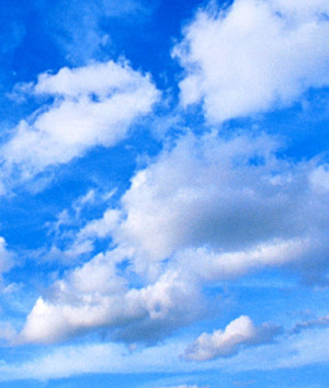 Cumulus clouds in blue sky under higher layer of cirrus clouds.