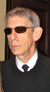 gray-haired man with lined face and sunglasses