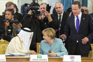 Merkel sits on the place of Britain's Prime Minister Cameron ...