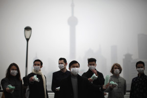 distribute face masks to pedestrians to raise awareness of pollution ...