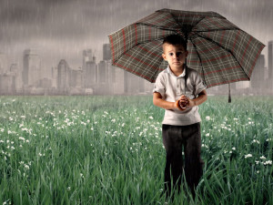 Alone boy with umbrella in rainy season