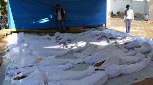 Syrian activists inspect the bodies of people they say were killed by ...