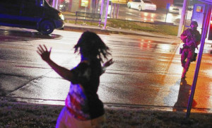 confronts a demonstrator during ongoing protests in Ferguson, Mo ...