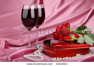 Heart-shaped red box with sweets, two glasses of red wine and bunch of ...