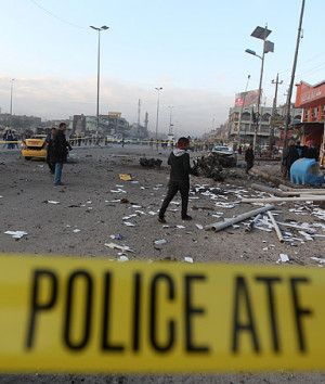 Iraqi security forces and civilians inspect the site of a blast after ...