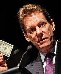 BUSINESS. Ivanhoe founder and CEO Robert Friedland holds up a US $100 ...