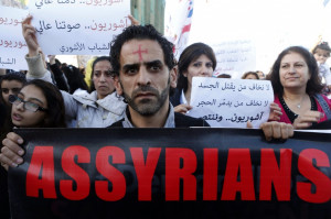 Assyrians hold banners as they march in solidarity with the Assyrians ...