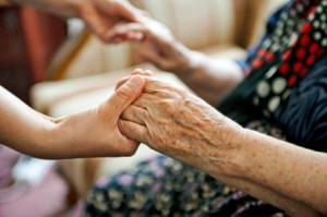 Volunteer holding elderly person's hand