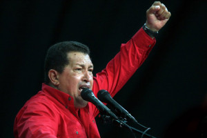 Venezuela's President Hugo Chavez raises his fist as he delivers a ...