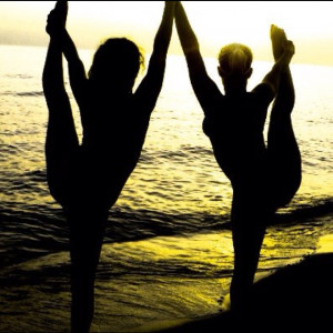 Cheerleading heel stretches on the beach at sunset