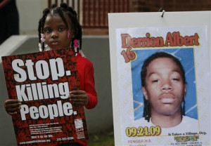 sign beside a poster with his picture at Fenger High School in Chicago ...