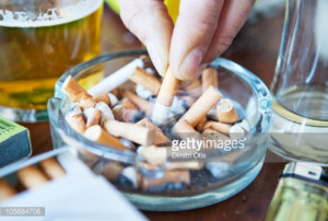 put out in ashtray caption cigarette being put out in full ashtray ...