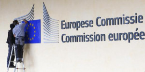 Workers adjust and clean the logo of the European Commission at the ...