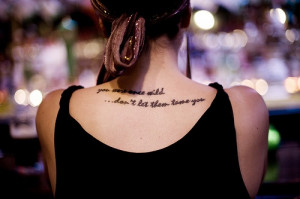 ... once wild …don’t let them tame you” quote tattoo on girls back