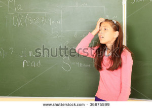 Educational theme: funny schoolgirl in a classroom. - stock photo