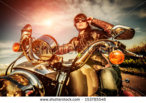 Biker girl in a leather jacket on a motorcycle looking at the sunset ...