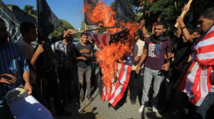 Palestinians burn the US flag during a demonstration against an anti ...