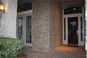 Large stone and brick front porch showing the Study French doors and