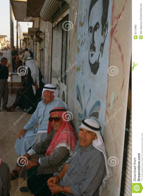 Men sitting under a picture of Hafez Al Assad Syria Editorial Photo