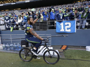 Seattle Seahawks defensive end Michael Bennett (72) rides a bicycle ...