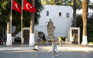 woman walks past by a statue of modern Turkey's founder Mustafa ...