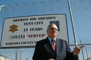 Maricopa County Sheriff Joe Arpaio stands in front of a sign touting ...