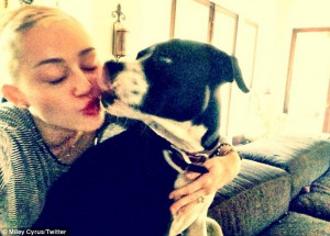 In another shot, Miley is seen cuddling her dog Mary Jane close, while ...