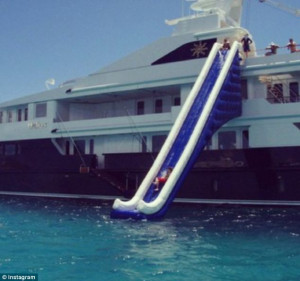Splash in the ocean: A 'rich kid' speeds down an inflatable slide into ...