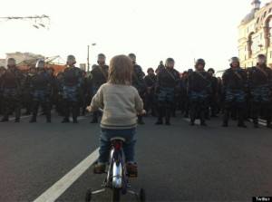 photo shows a child bicycling toward Russian police. (@IOFFEINMOSCOW ...