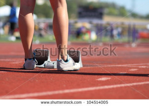Female athlete sprinter standing behind starting block at the starting ...