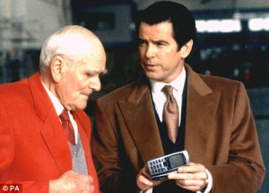 Desmond Llewelyn as Q shows Pierce Brosnan the Quartermaster a