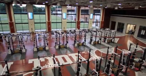 The weight room features floor-to-ceiling windows.