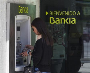 woman uses a Bankia bank automated teller machine (ATM) in Madrid ...