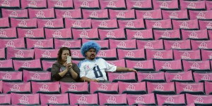 fans sit among breast cancer awareness posters before an NFL football ...